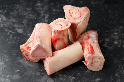 Raw beef bones on a dark surface
